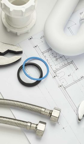 A selection of plumbing tools and fittings on house plans